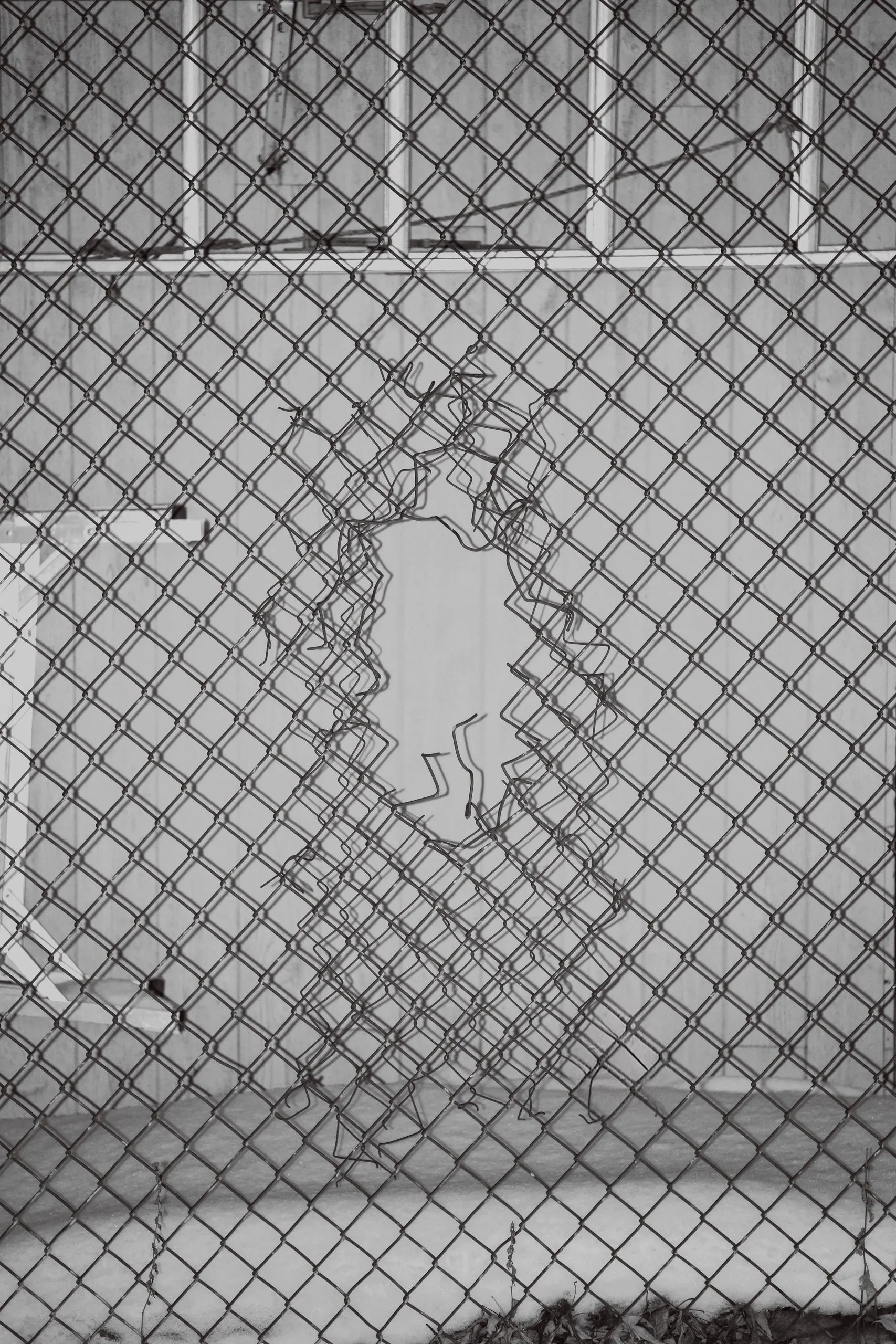 Trou dans un grillage en noir et blanc