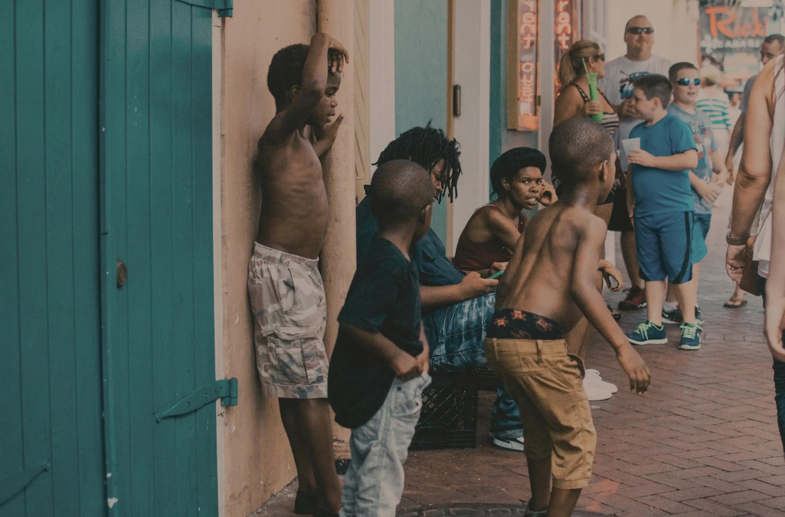 Plusieurs enfants afro-américains dansent devant des touristes dans une rue la Nouvelle Orléans. 