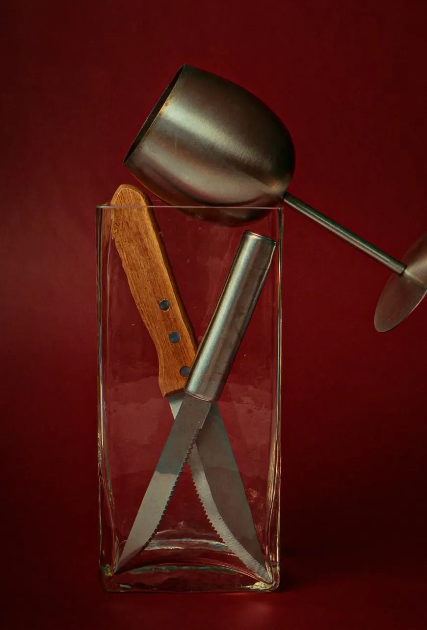 Assemblage abstrait de plusieurs ustensiles de cuisine : un verre dans un pot en verre. 