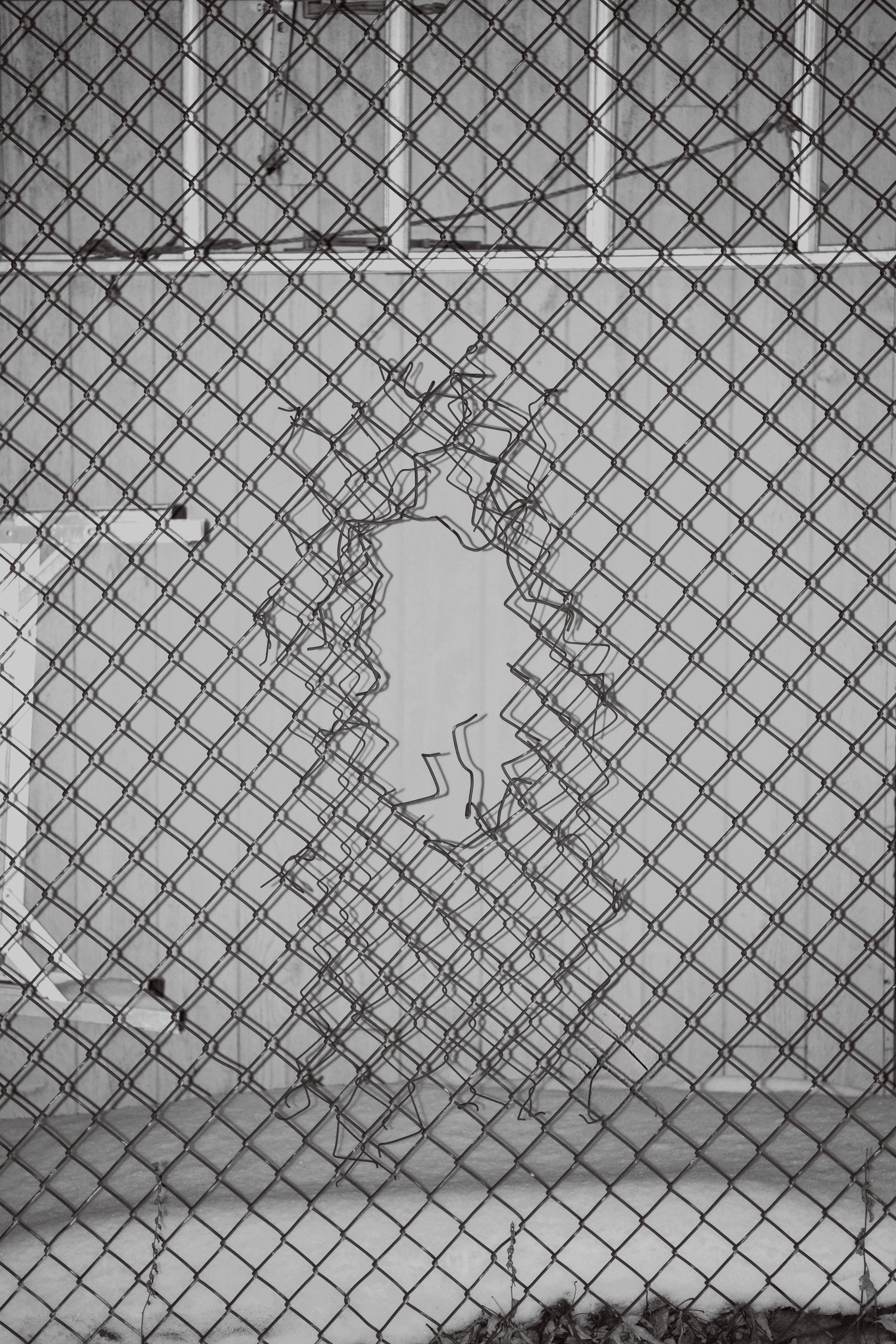 Trou dans un grillage en noir et blanc