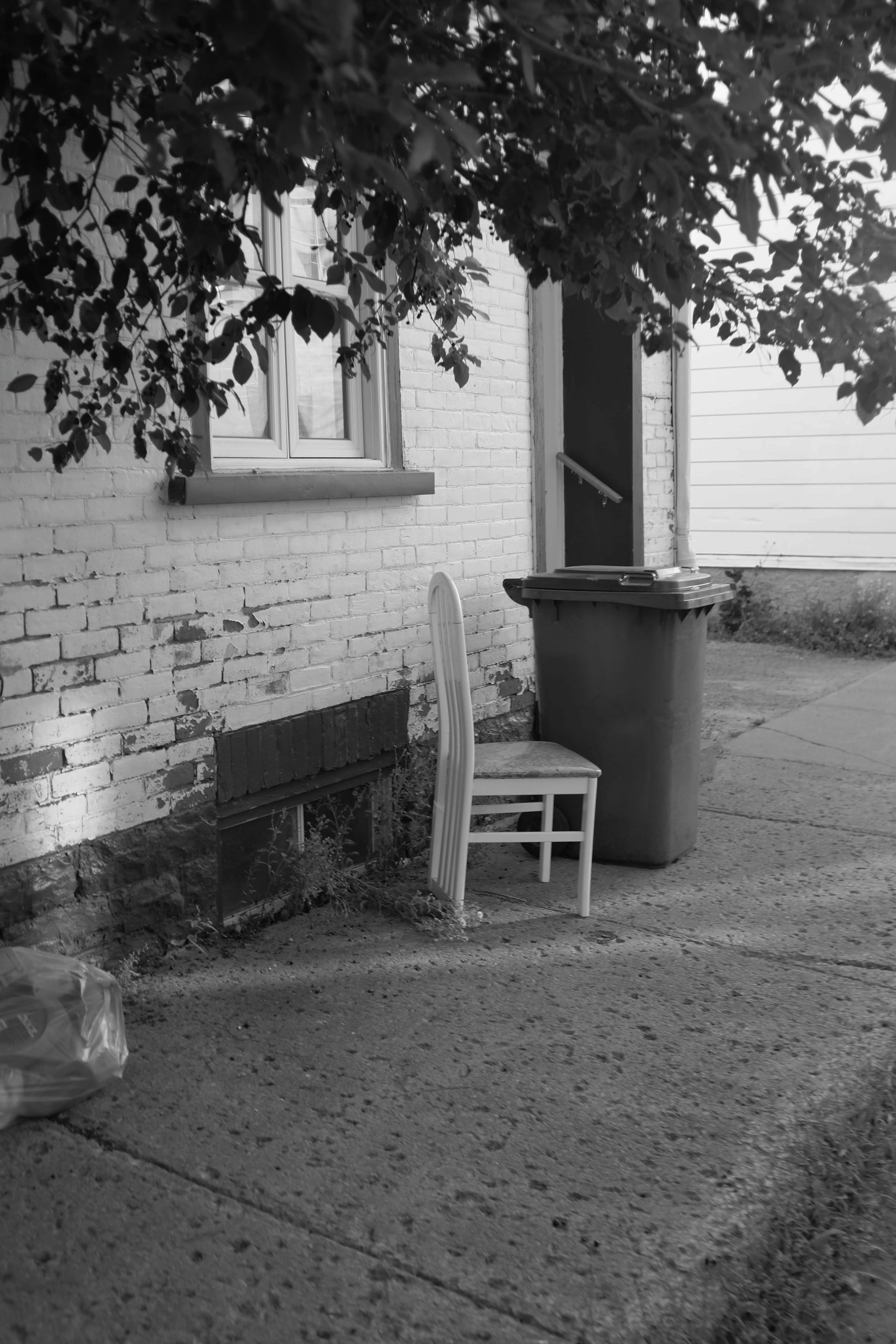Assise solide une chaise abandonnée devant une immeuble dans la rue