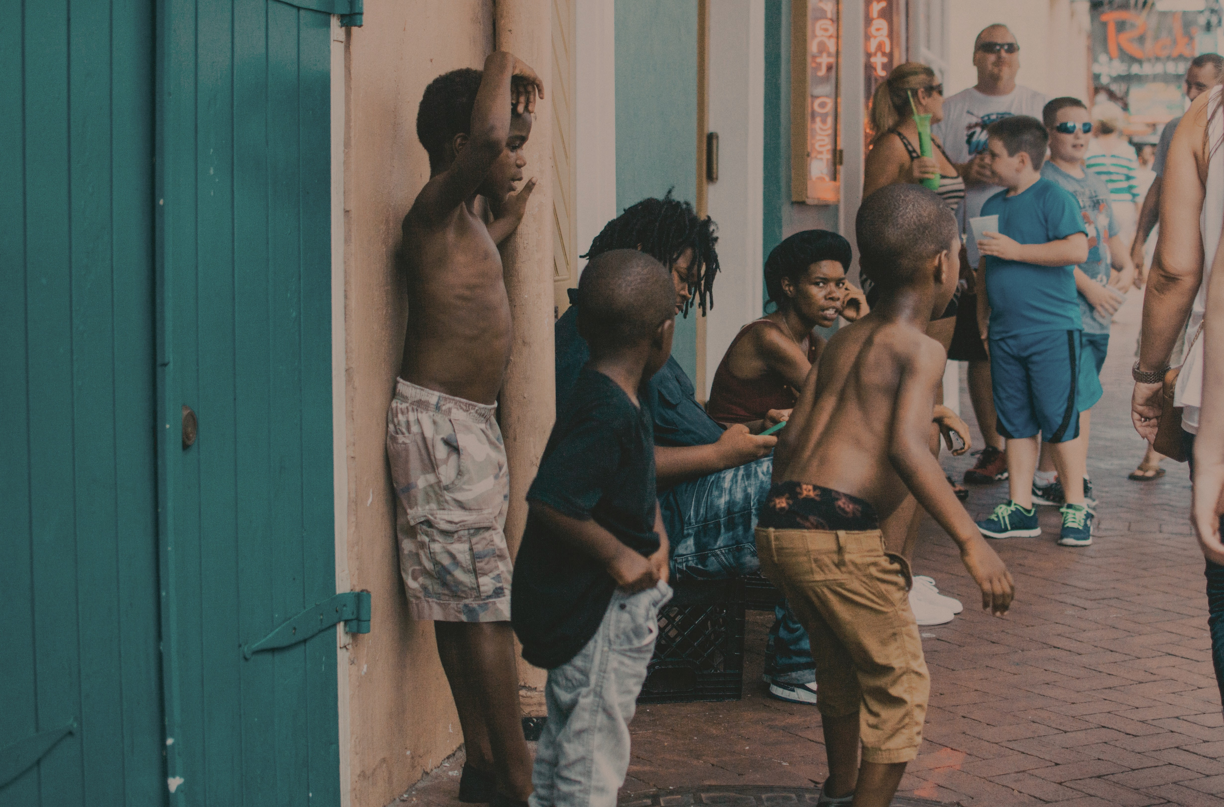 Plusieurs enfants afro-américains dansent devant des touristes dans une rue la Nouvelle Orléans. 